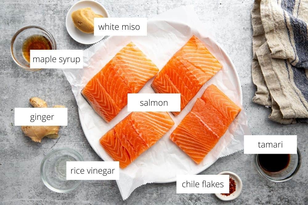 All of the ingredients for the miso salmon recipe on a work surface with labels.