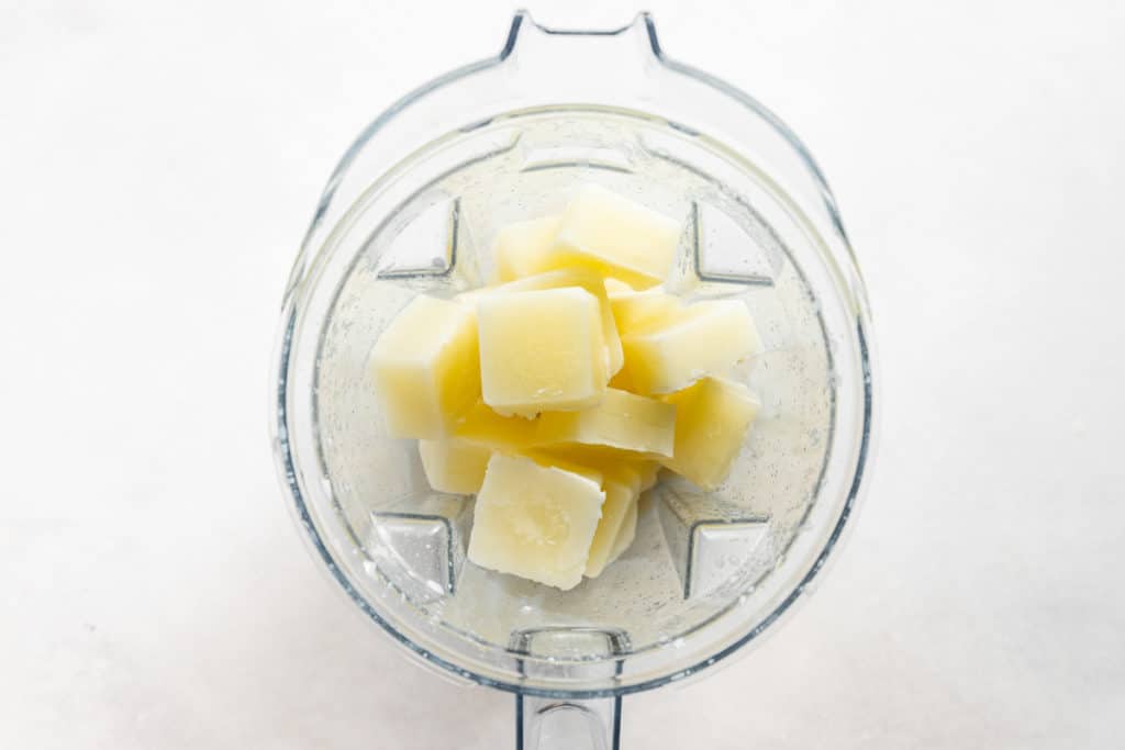 Process shot showing frozen milk cubes in a Vitamix blender. 