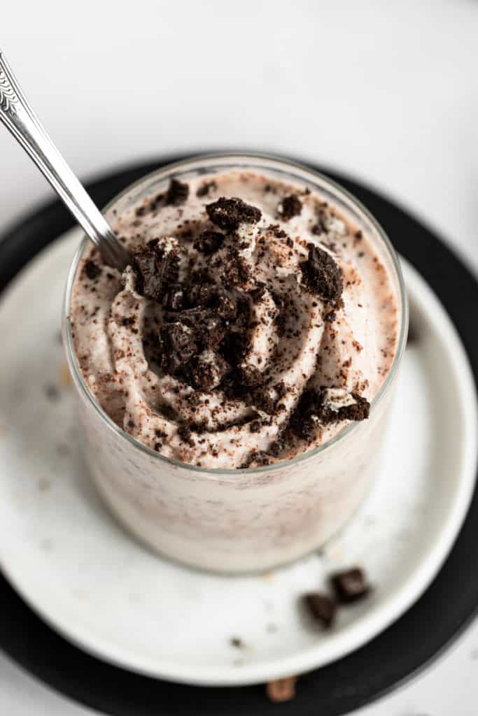 Close up of a DIY blizzard from scratch in a glass topped with crushed chocolate cookies.