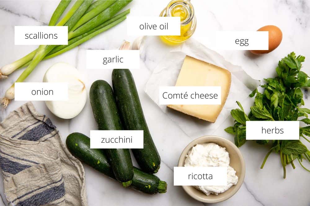 All of the ingredients for the vegetarian zucchini boats recipe on a work surface with labels.