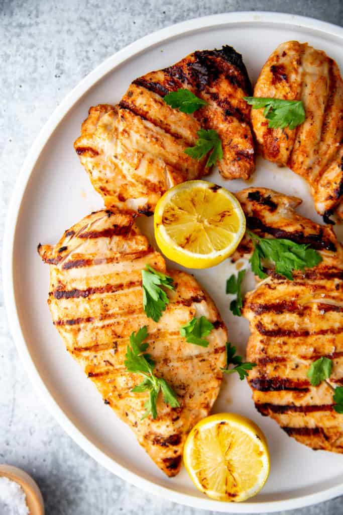 Yogurt marinated grilled chicken breasts and thighs on a platter.