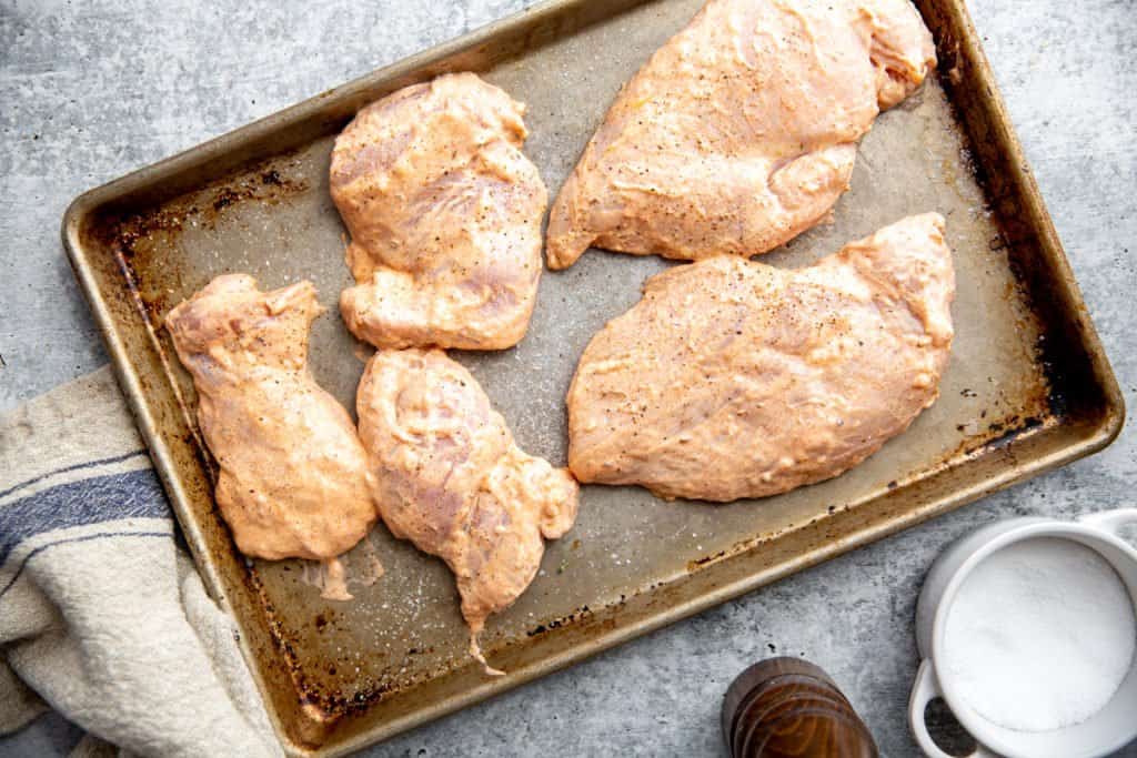 The marinated chicken on a sheet pan.