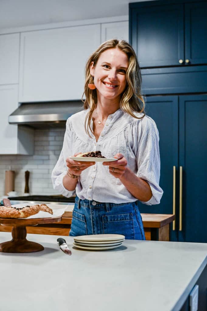 Nicki Sizemore in her kitchen holding a plate of pie.