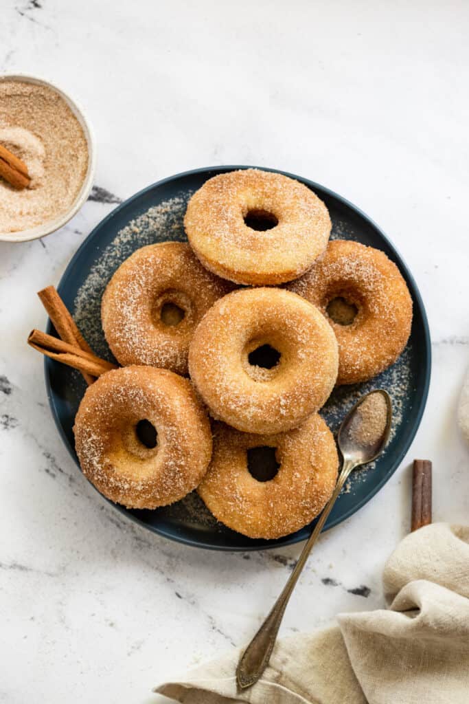 Gluten free baked cinnamon sugar donuts on a plate.