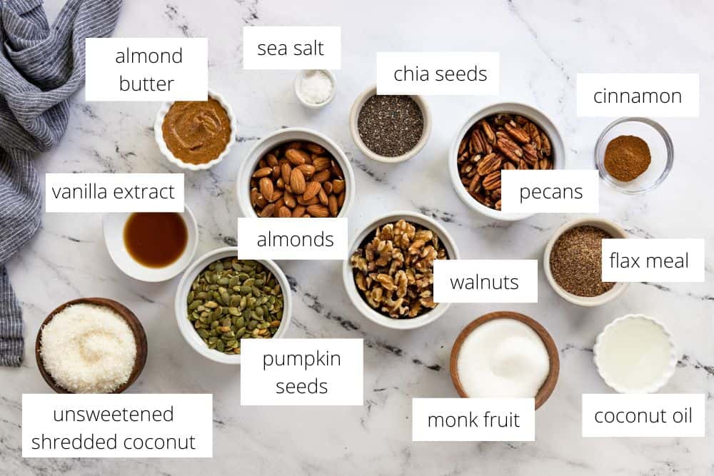 All of the ingredients for the Grain Free Granola recipe on a marble surface with labels.