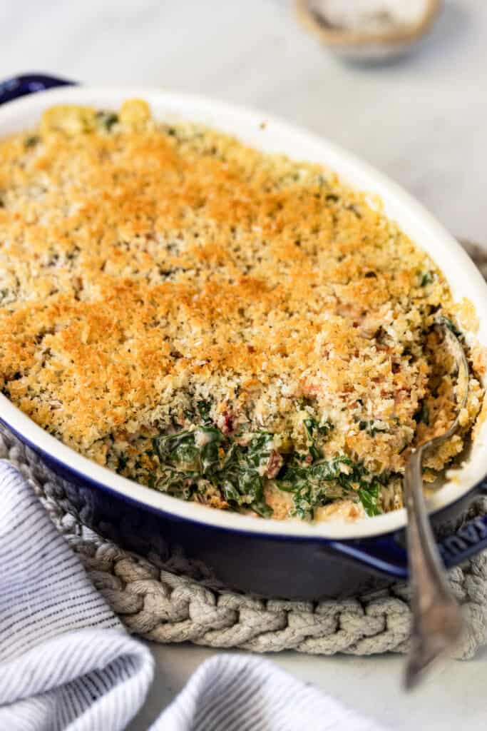The finished gratin in a baking dish with a serving spoon. 