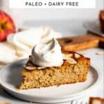 A slice of gluten free apple cake on a plate with whipped cream