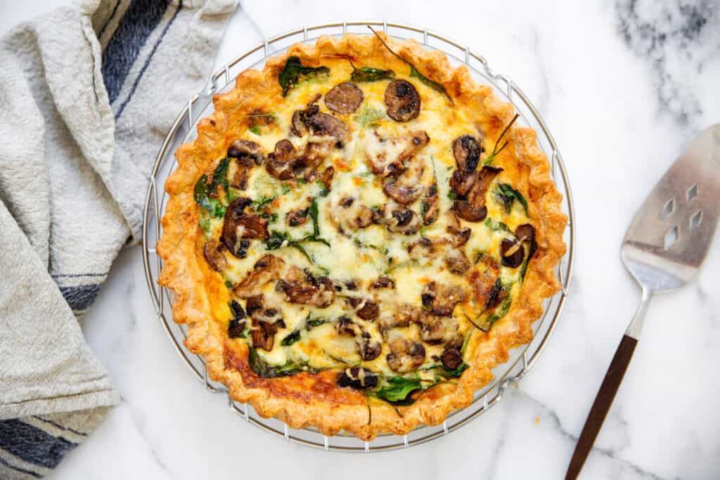 A gluten free spinach and mushroom quiche on a cooling rack. 