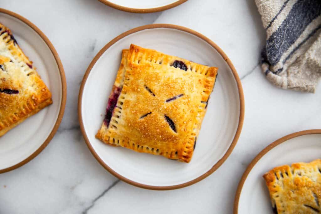 a hand holding a blueberry hand pie