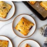 Blueberry hand pies on a marble surface.