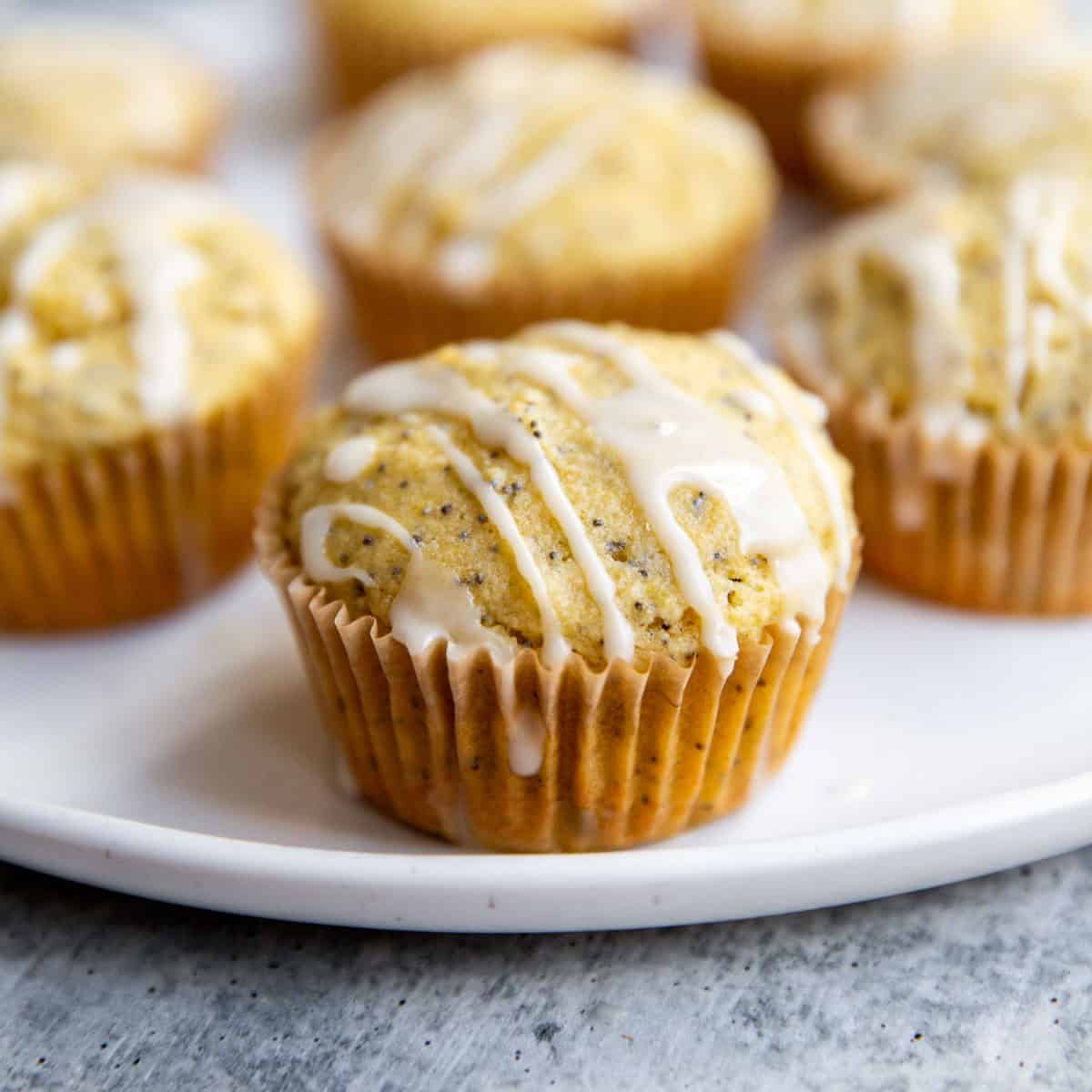 Lemon poppyseed muffins with lemon glaze arranged on a serving plate