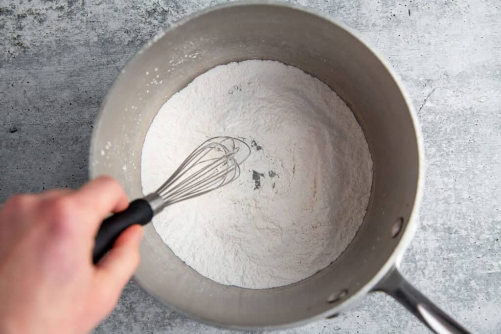 whisking dry ingredients in a metal mixing bowl