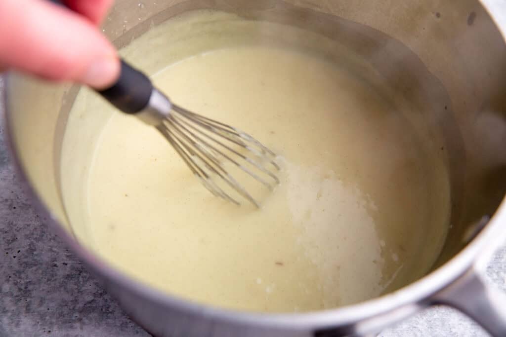 whisking the custard in a saucepan