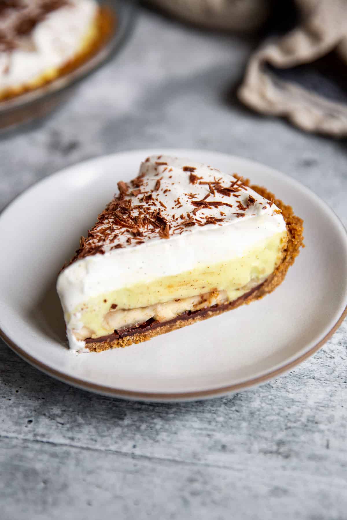 a slice of vegan banana cream pie on a white plate