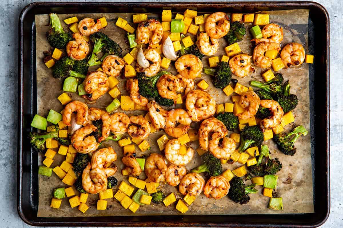 cooked shrimp and veggies on a sheet pan