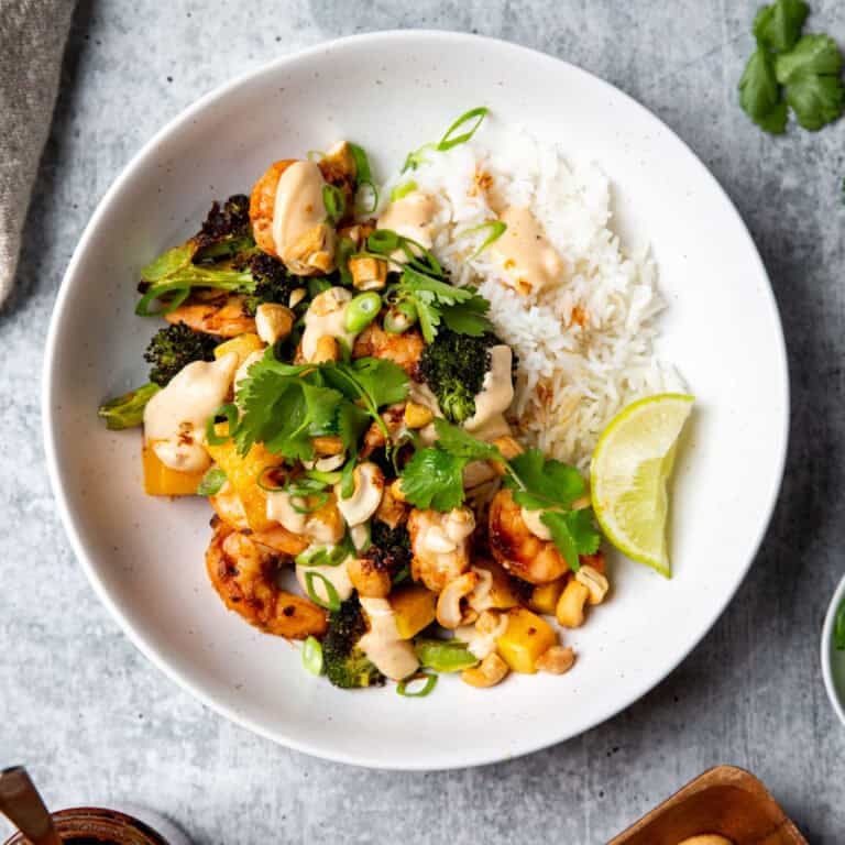 chili crisp shrimp atop rice and veggies in a white bowl