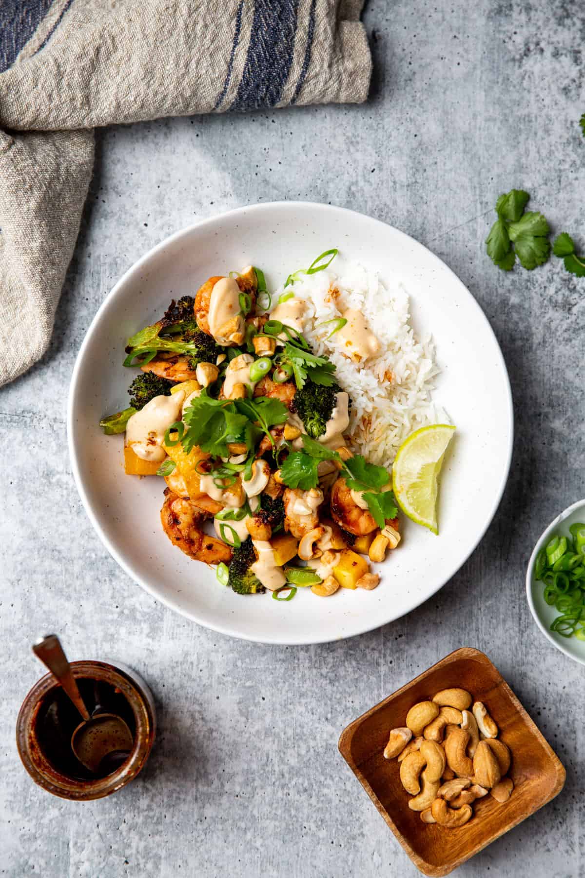 chili crisp shrimp atop rice and veggies in a white bowl