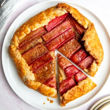 a rhubarb galette on a white plate with one slice resting on the side