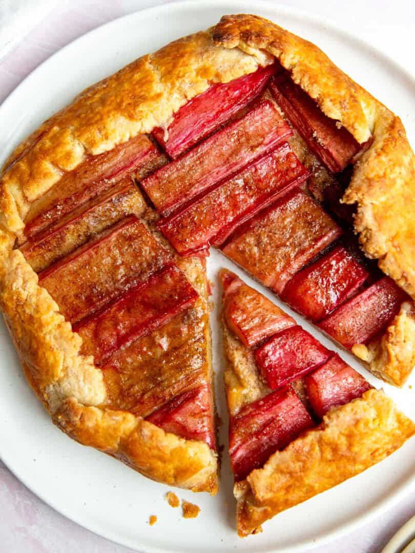 a rhubarb galette on a white plate with one slice resting on the side