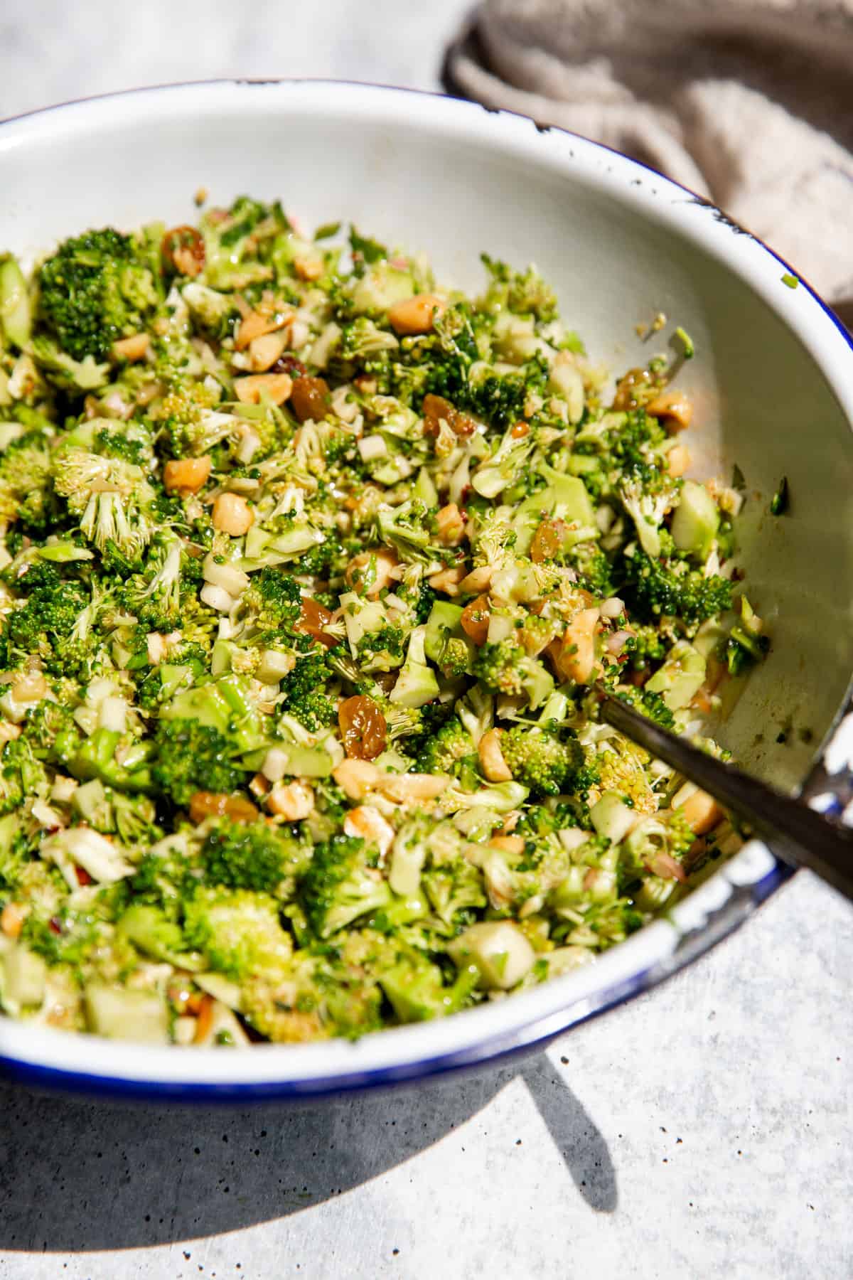 broccoli crunch salad in a large serving bowl with a spoon resting on the side