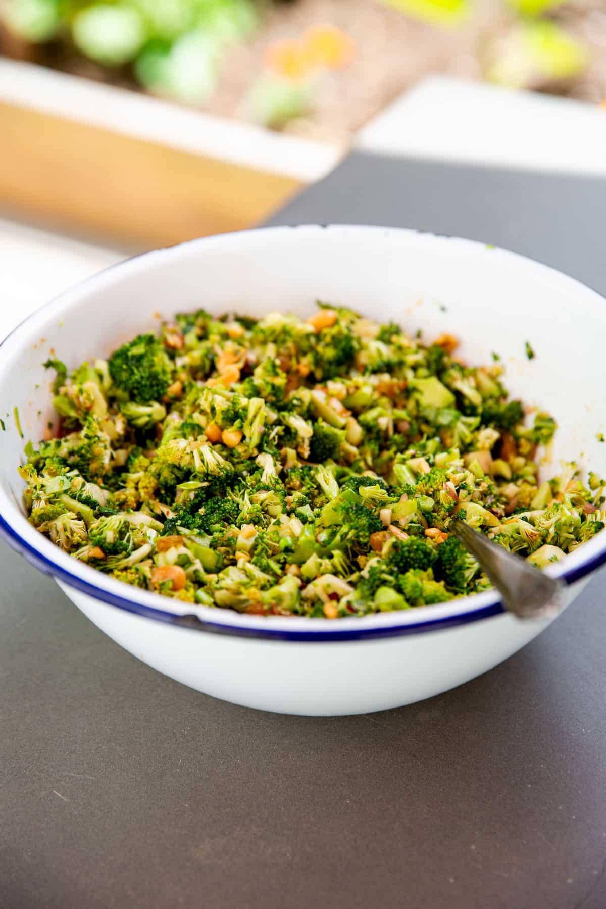 a serving bowl on a table filled with broccoli crunch salad