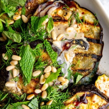 an up close photo of eggplant and zucchini on a white plate