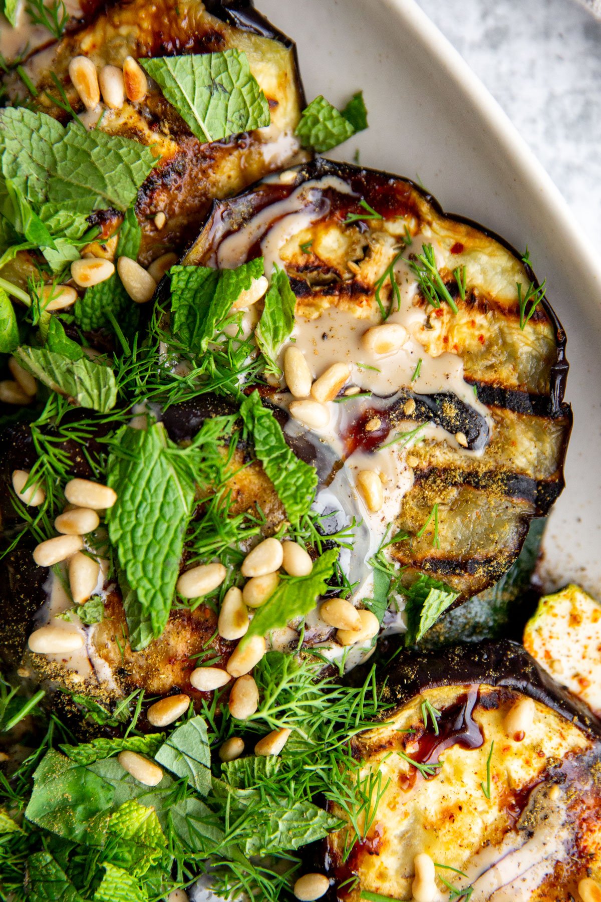 an up close photo of eggplant and zucchini on a white plate 