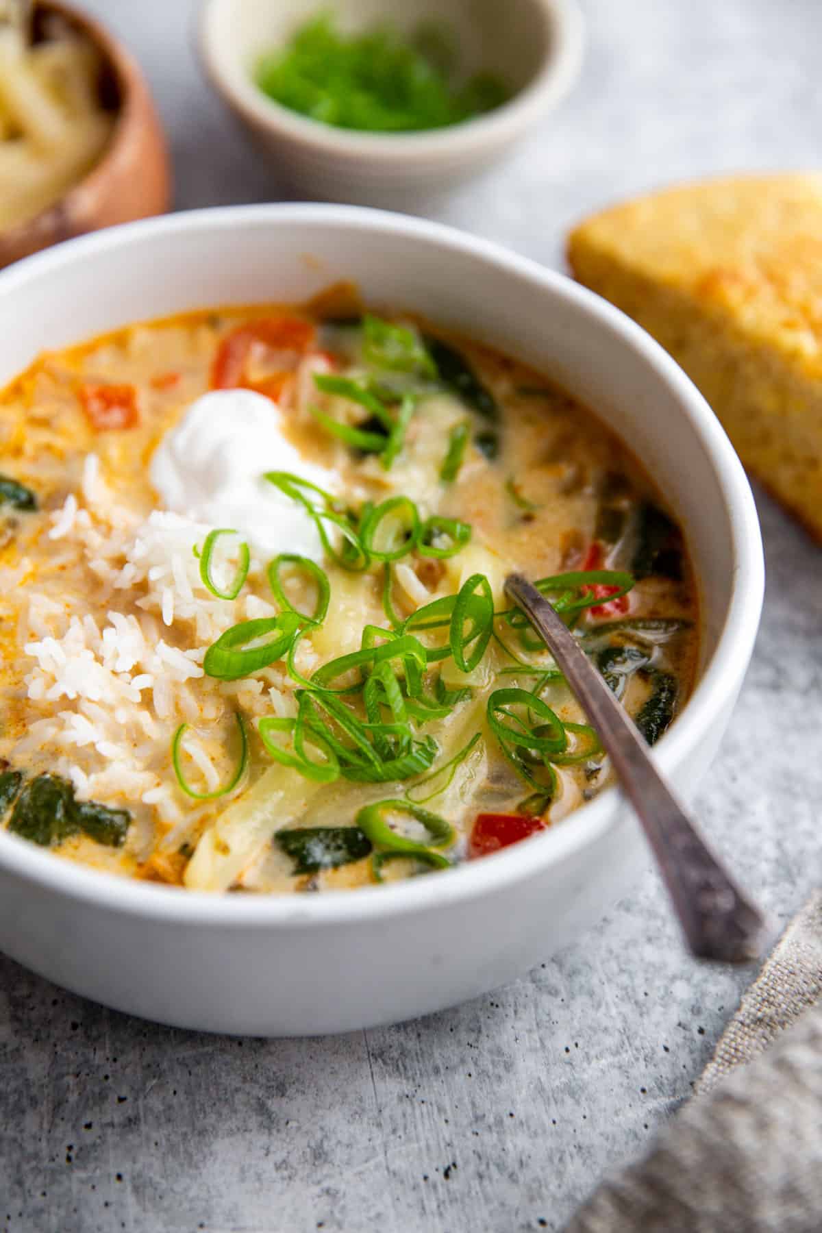 a bowl of creamy white bean soup topped with sour cream and green onions