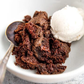 double chocolate spoon cake topped with vanilla ice cream in a white bowl