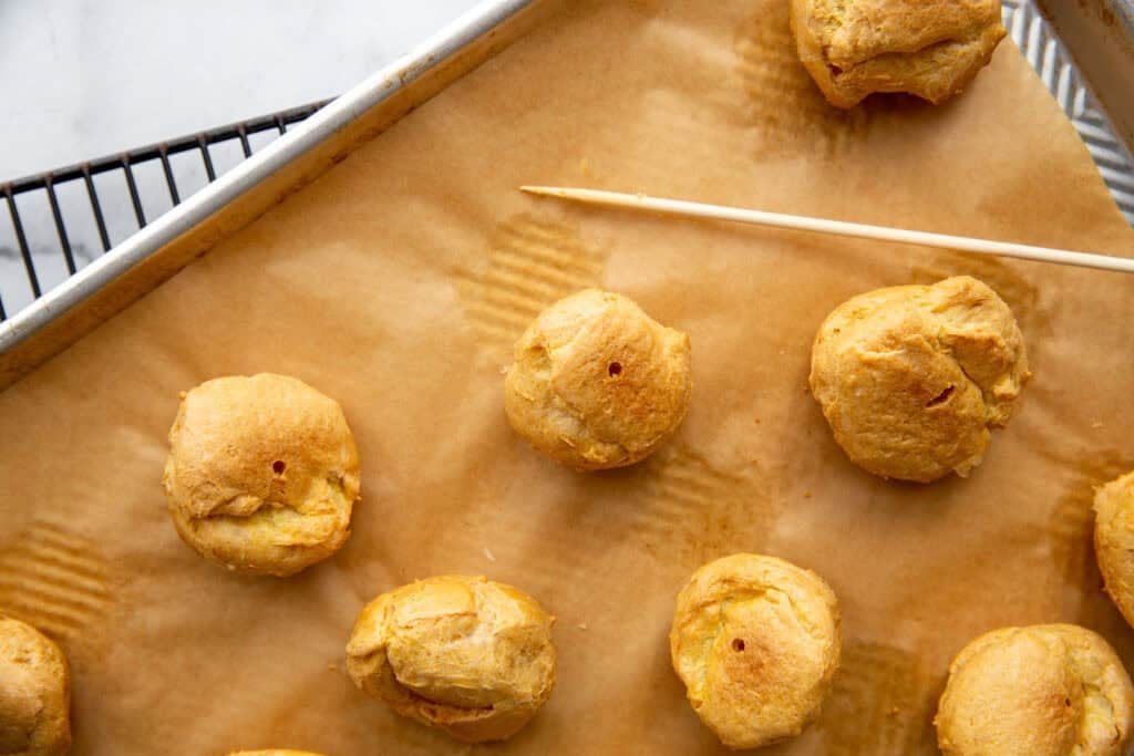 a hole poked in the bottom of each cream puff shell