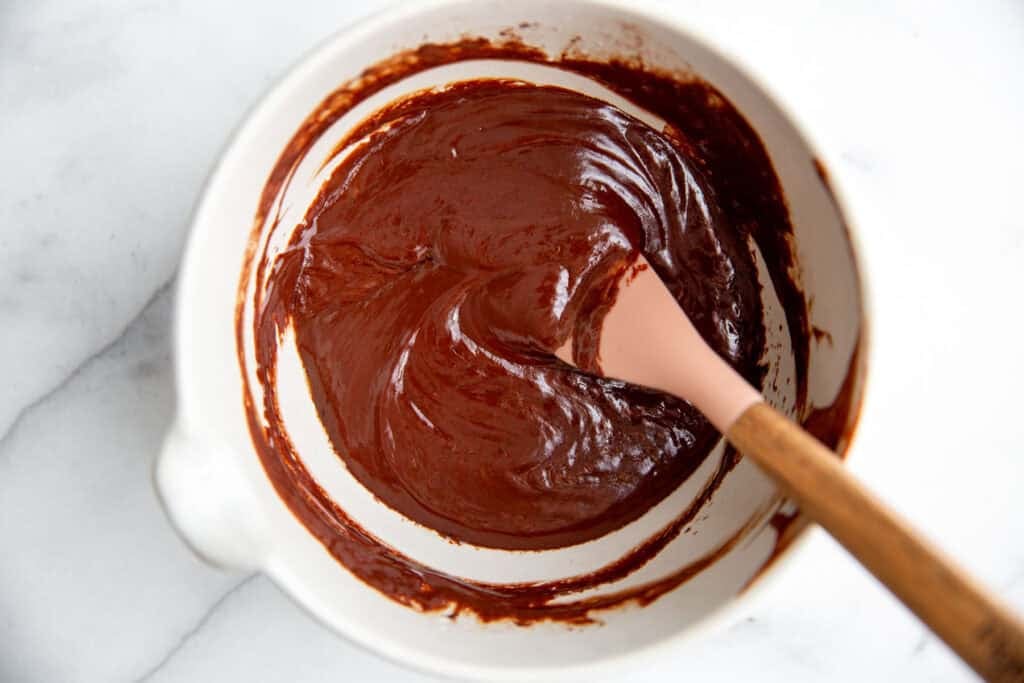 chocolate ganache in a bowl with a rubber spatula 