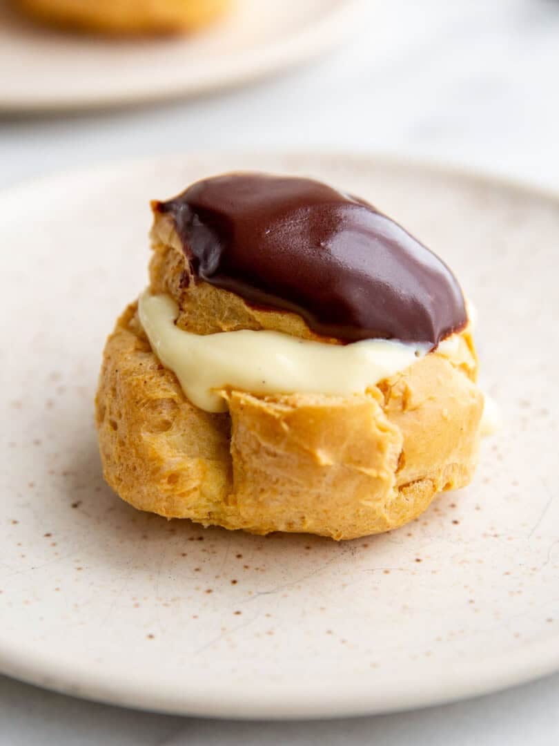 a gluten-free cream puff filled with pudding and topped with chocolate