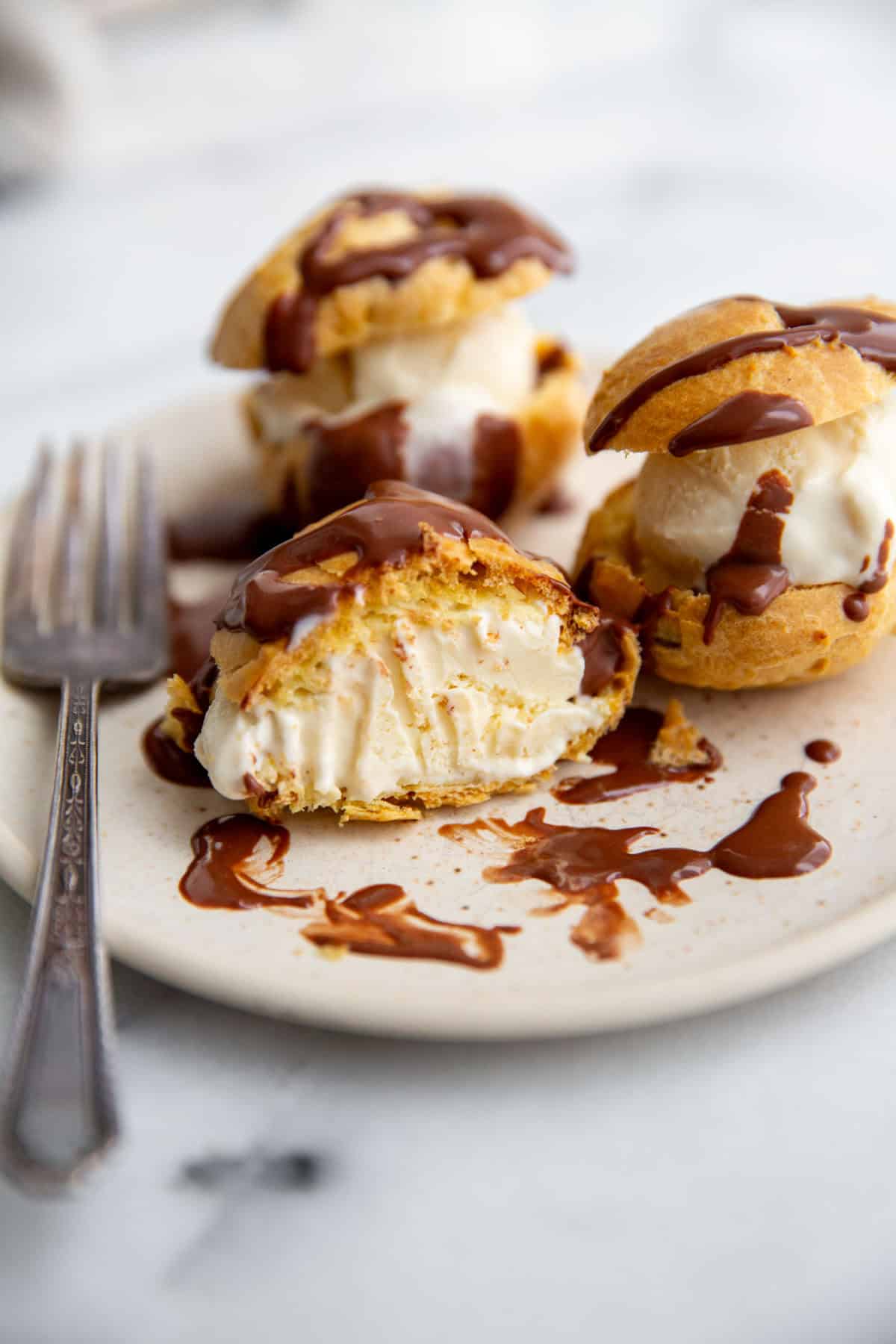 gluten-free cream puffs filled with ice cream and topped with chocolate ganache