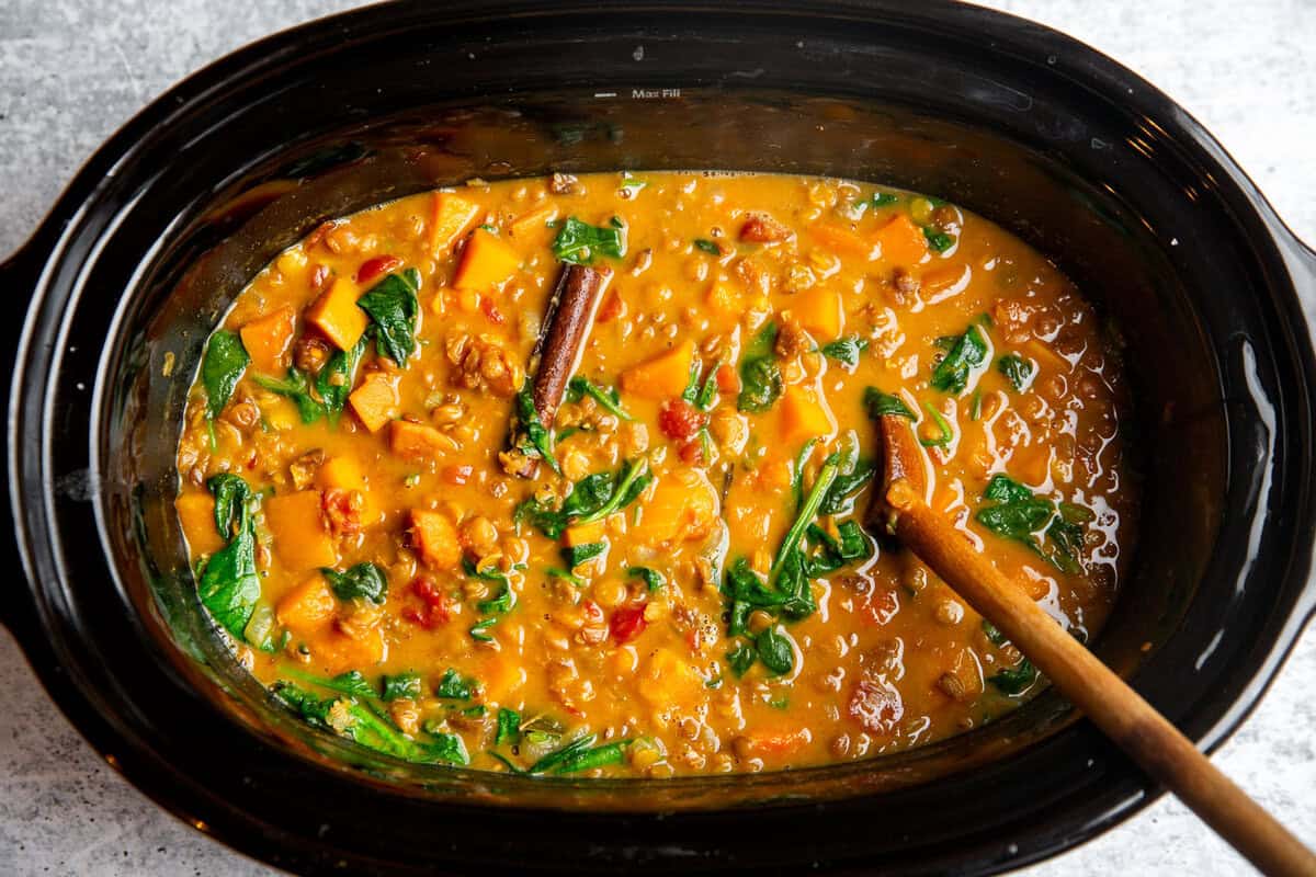 a slow cooker filled with butternut squash and lentil stew