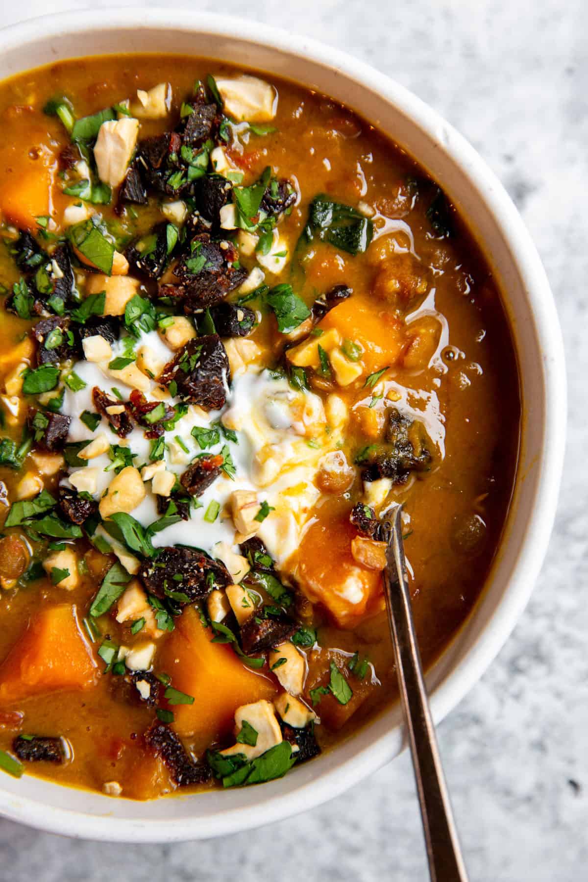 stew in a bowl topped with yogurt and gremolata