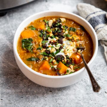 a bowl of stew topped with yogurt and gremolata