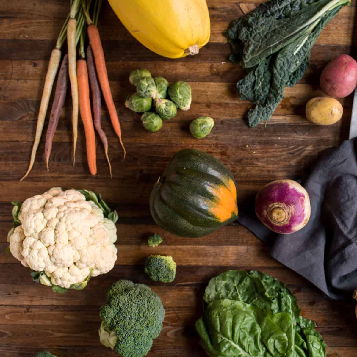 Overhead view of an assortment of Fall seasonal produce on a wooden tabletop