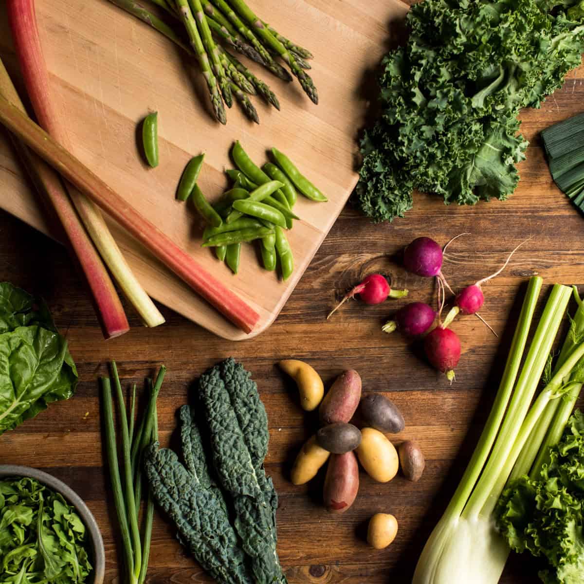 Seasonal Spring produce on a wooden cutting board.