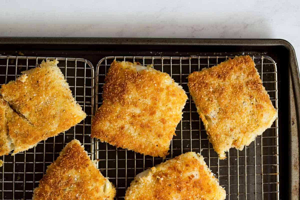 Crispy pan-fried fish draining on a wire rack to maintain crunchy exterior
