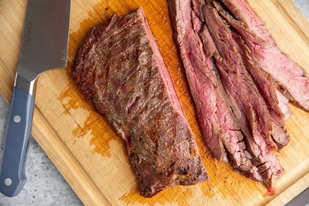 grilled steak slice on a wooden cutting board