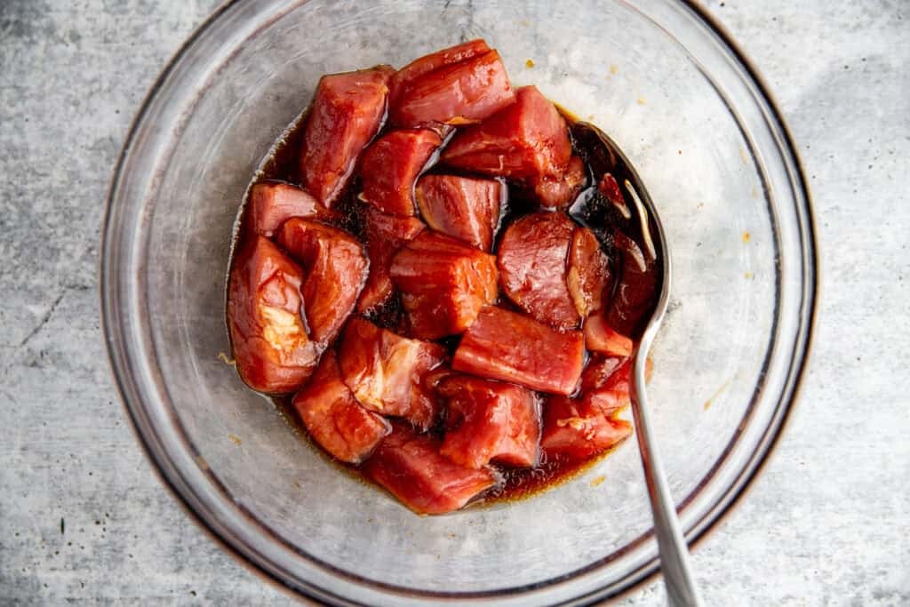 Chunks of pork tenderloin marinating in soy-maple mixture for kebabs