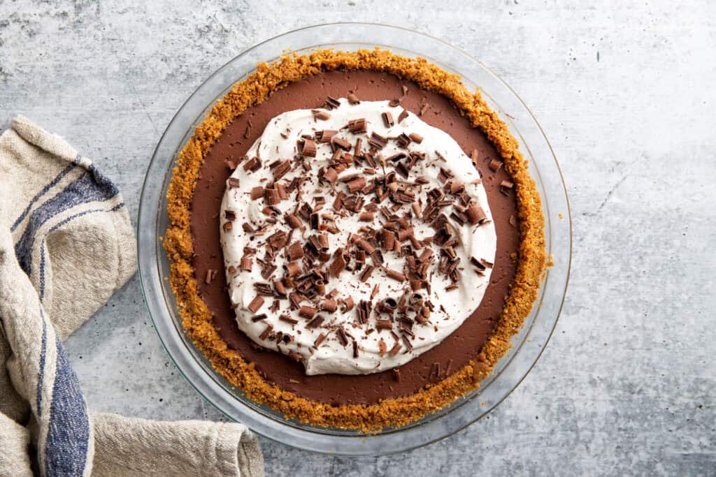chocolate shavings spread across the top of the whipped cream on a chocolate pudding pie