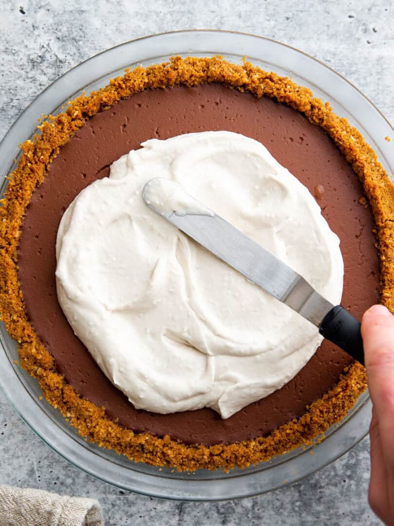 coconut whipped cream spreading on top of a pie