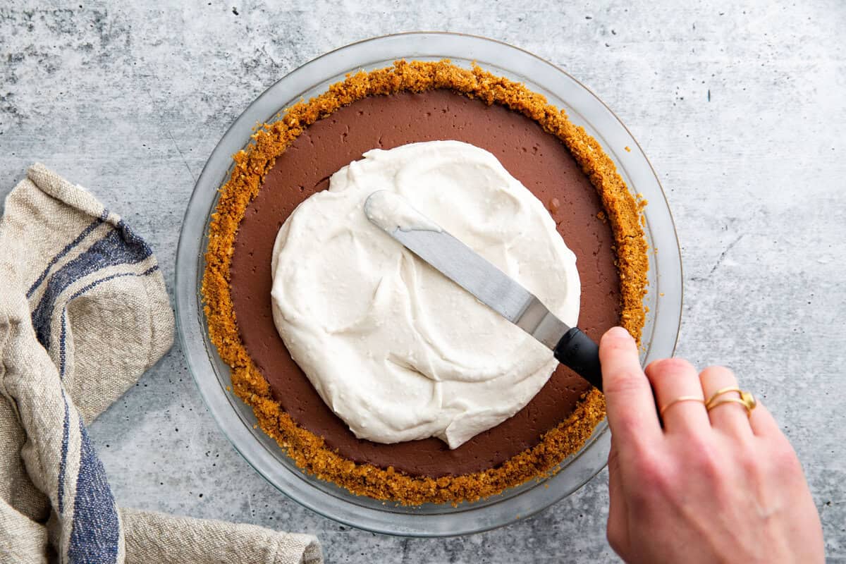 coconut whipped cream spreading on top of a pie