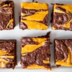 pumpkin cheesecake brownies cut into squares, with a visible swirl on top