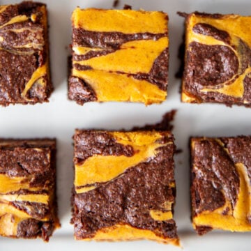 pumpkin cheesecake brownies cut into squares, with a visible swirl on top
