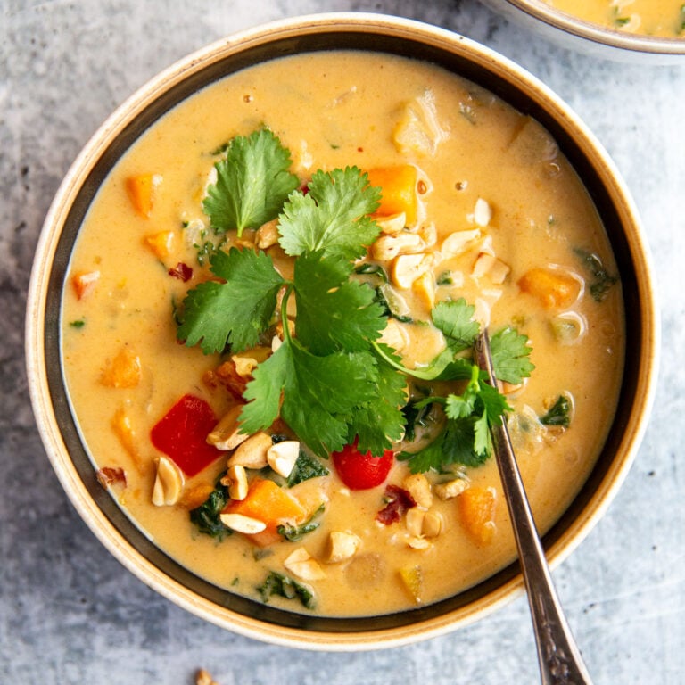 sweet potato peanut stew in a bowl topped with herbs
