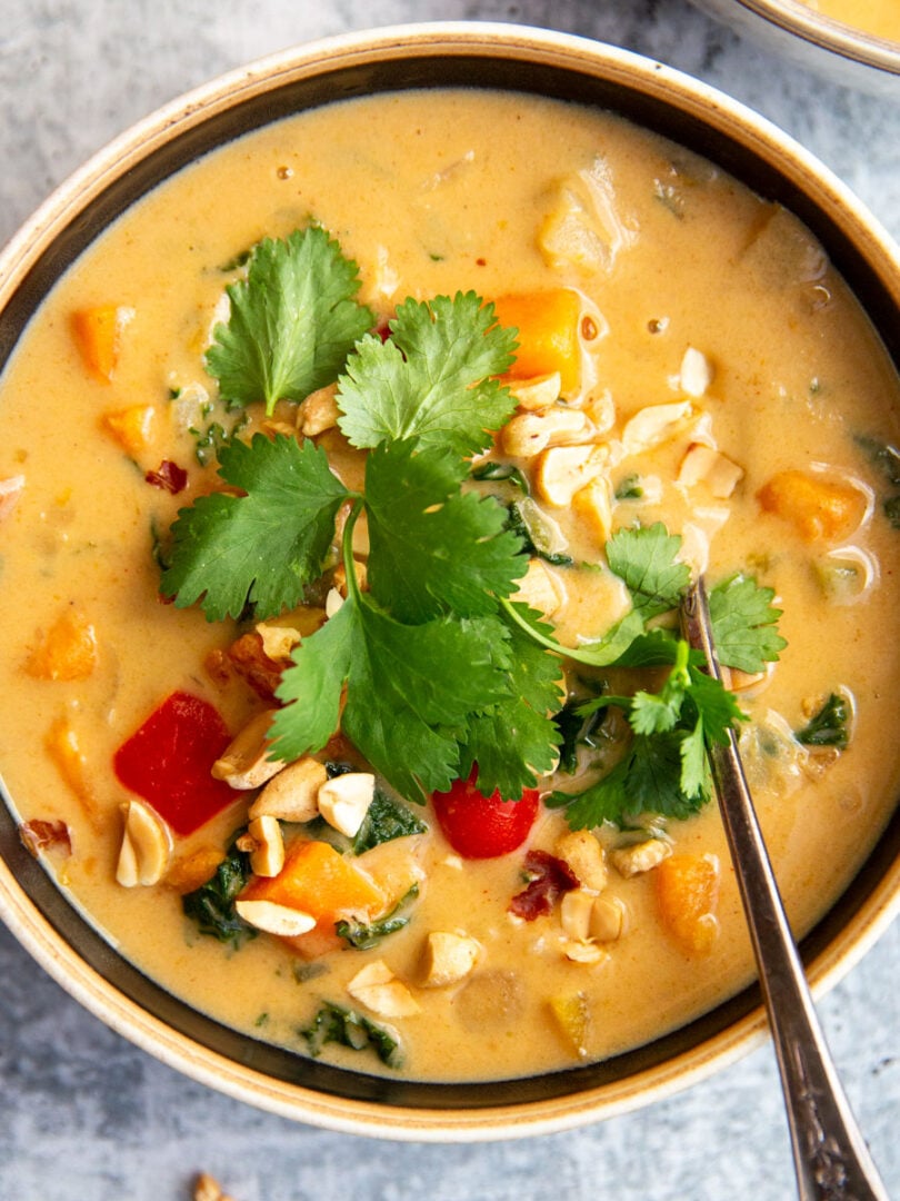 sweet potato peanut stew in a bowl topped with herbs