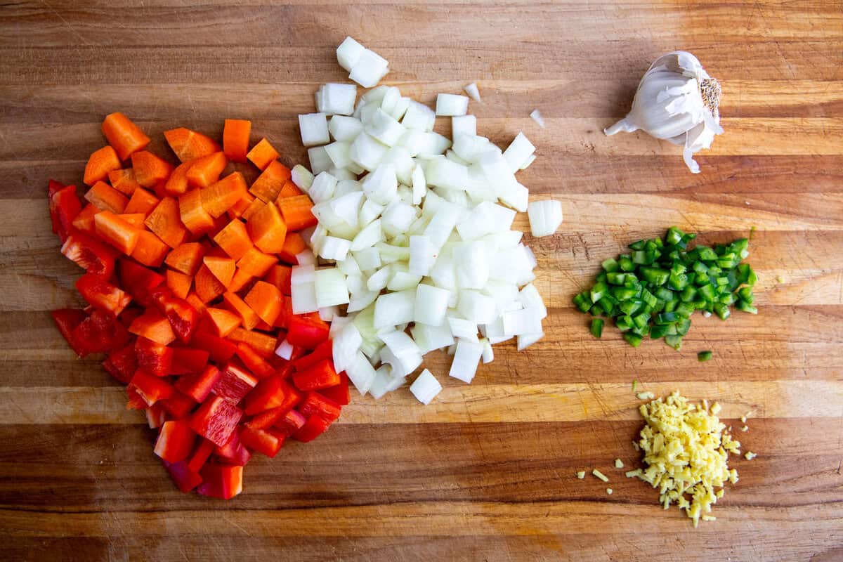 diced veggies on a cutting board ready to be used as ingredients in the sweet potato peanut stew