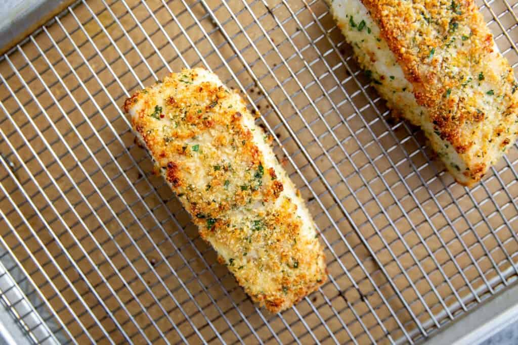 two baked fillets resting on a wire rack.